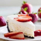 slice of Sour Cream Cheesecake topped with fresh strawberries.