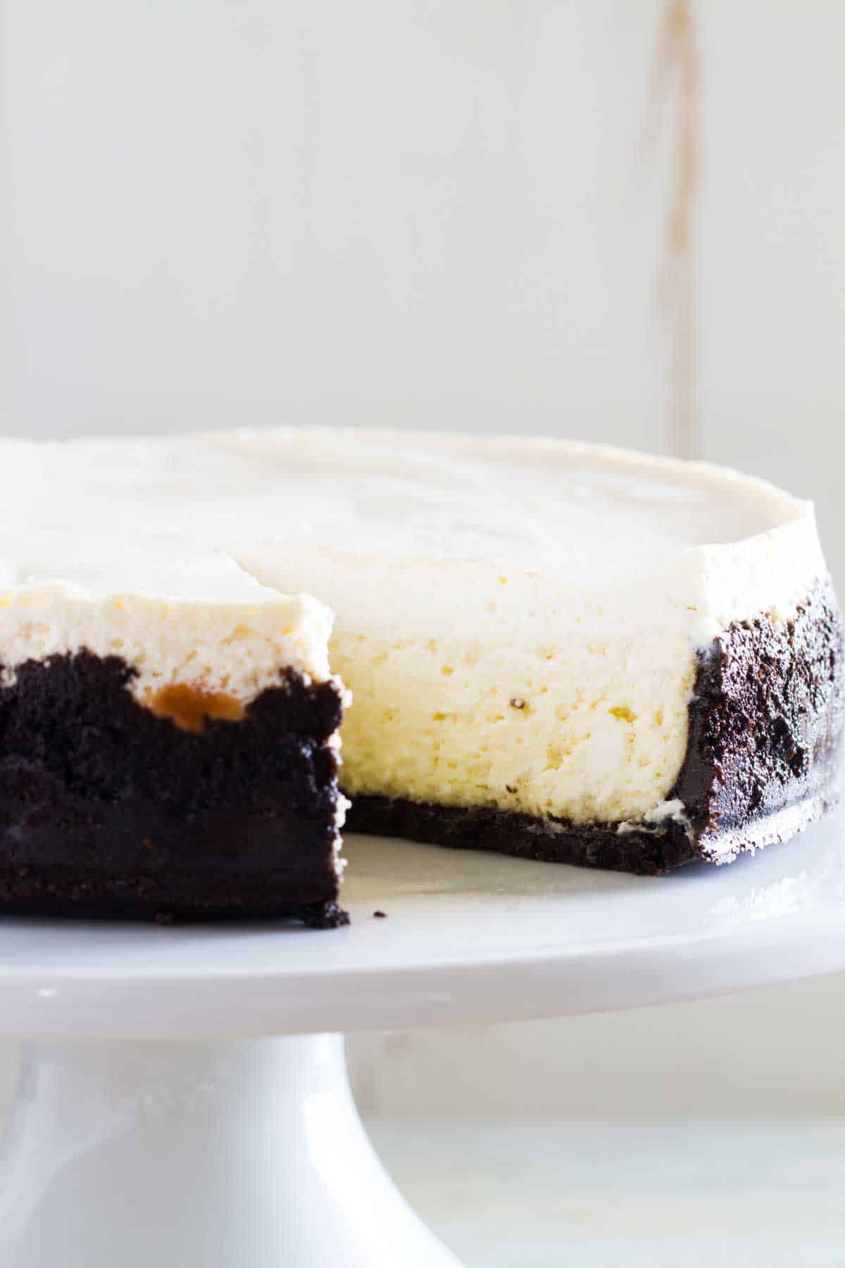 full sour cream cheesecake with a slice taken from it.