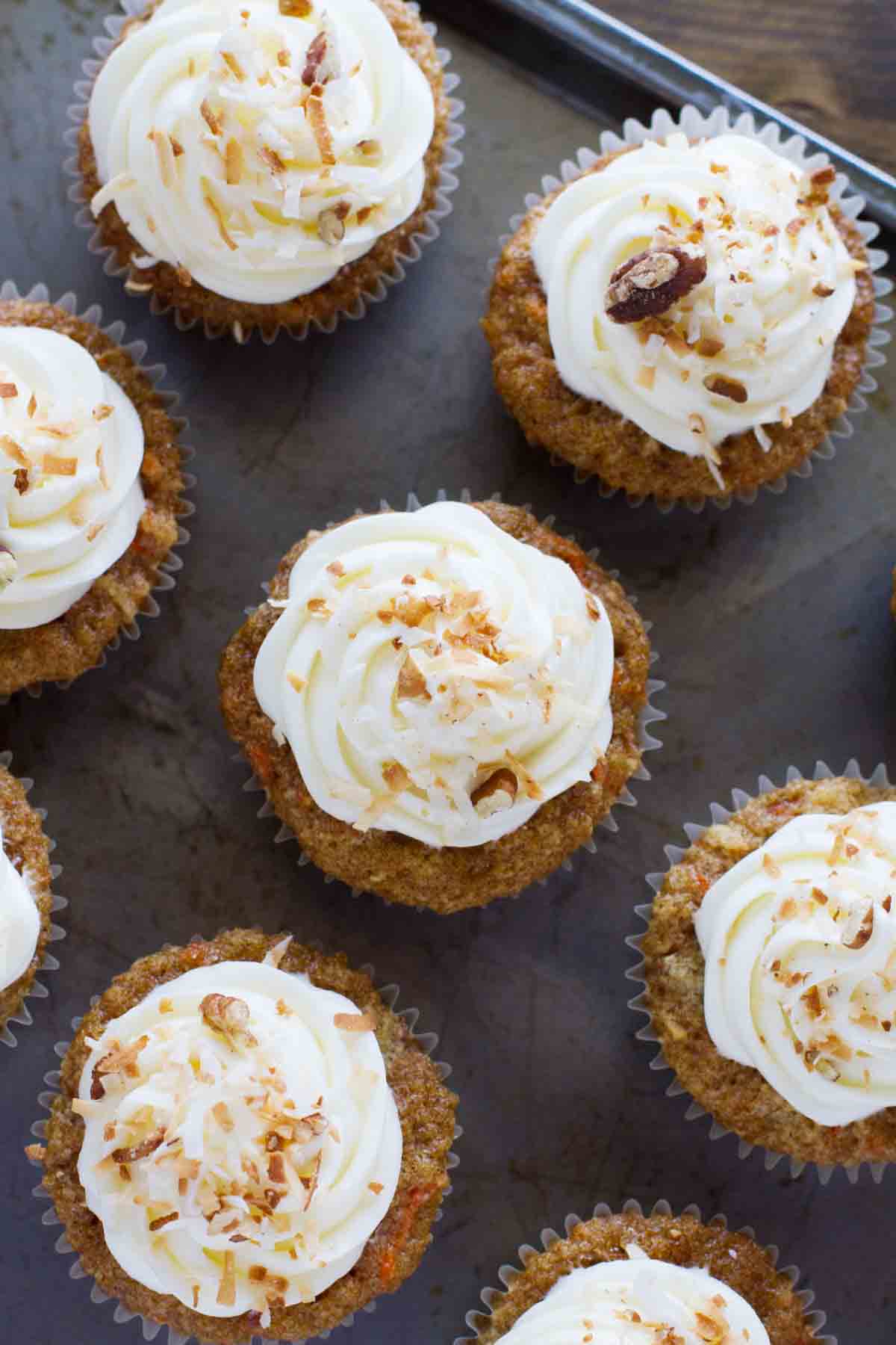 overhead view of carrot cake cupcakes on a baking sheet