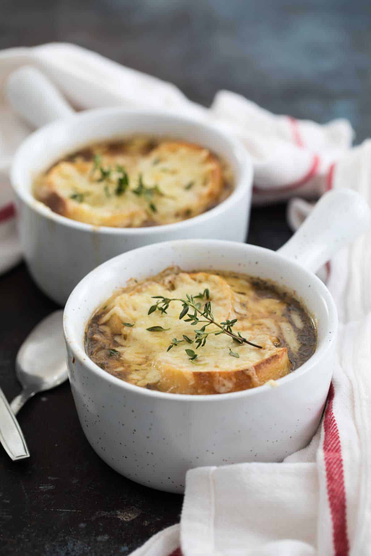 two bowls of French onion soup topped with bread and cheese