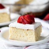 slice of Homemade Tres Leches Cake topped with a fresh strawberry