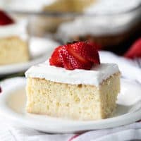 slice of Homemade Tres Leches Cake topped with a fresh strawberry
