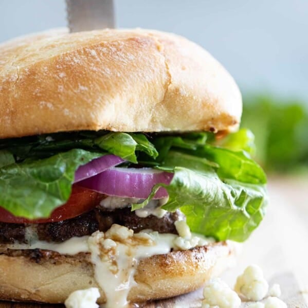 close up of blue cheese burger with a steak knife through it