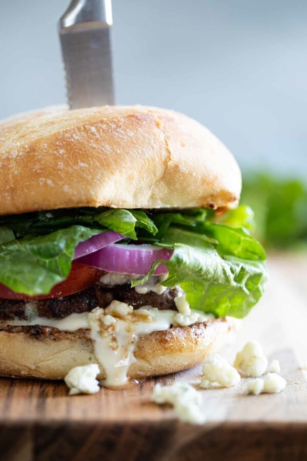 close up of blue cheese burger with a steak knife through it