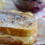 A mash up of 2 favorite sandwiches - a ham and cheese sandwich is slathered with a béchamel sauce, then battered and cooked in a skillet Monte Cristo style. Top with powdered sugar and raspberry jam if desired!