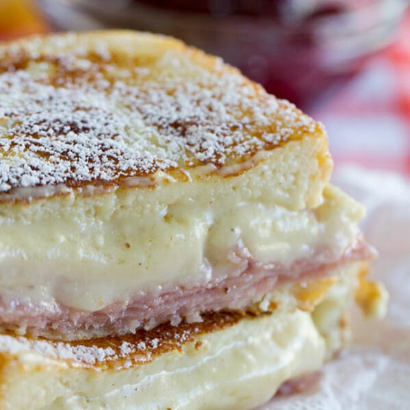 A mash up of 2 favorite sandwiches - a ham and cheese sandwich is slathered with a béchamel sauce, then battered and cooked in a skillet Monte Cristo style. Top with powdered sugar and raspberry jam if desired!