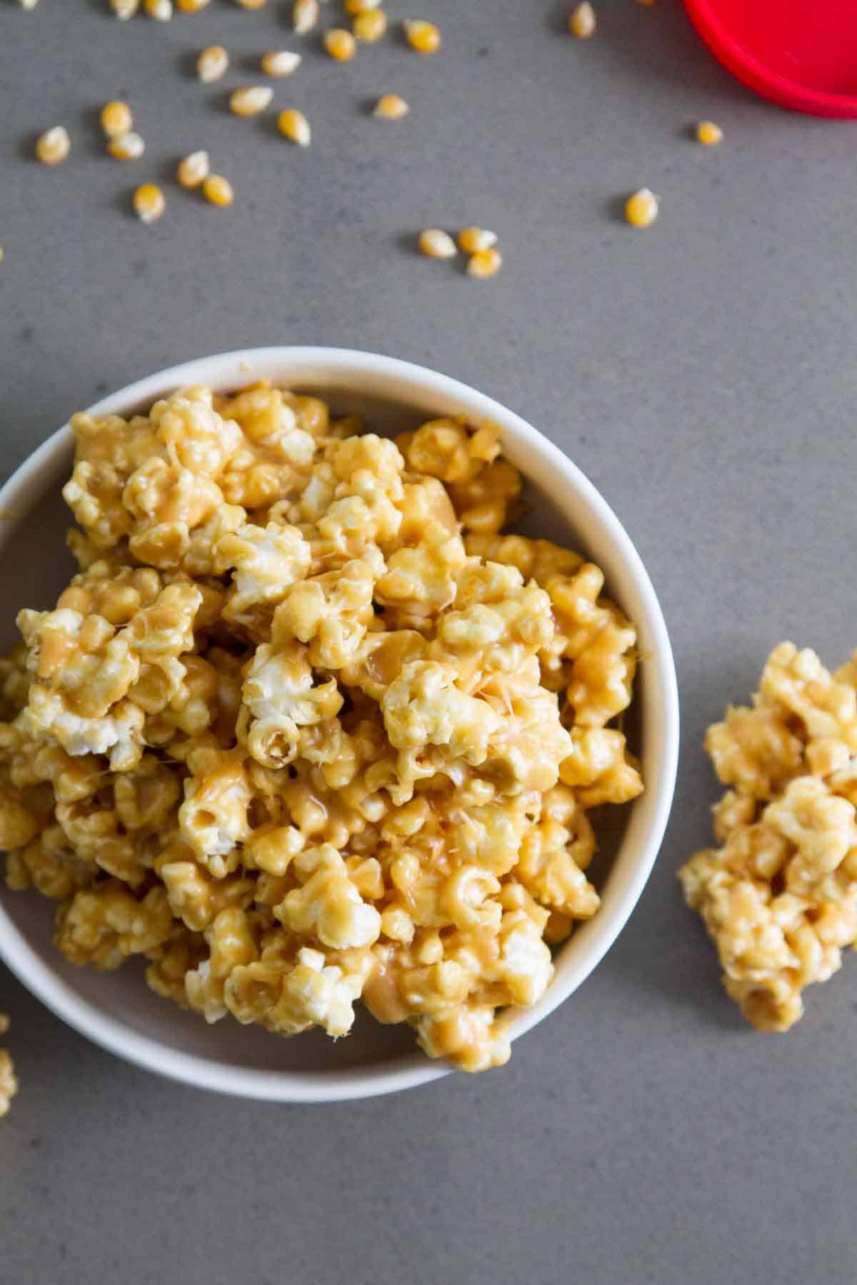 Bowl of peanut butter popcorn with popcorn spilling out.
