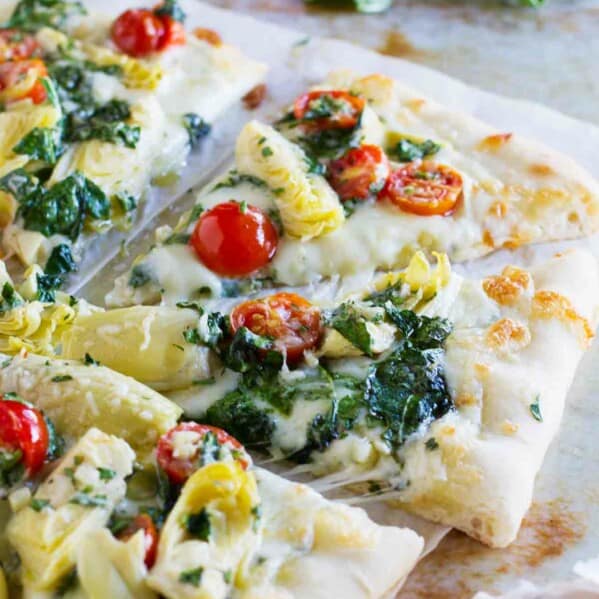 Pizza topped with artichokes, tomatoes and spinach