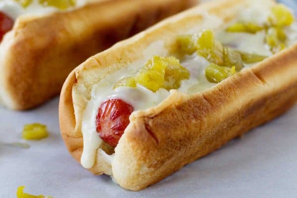 These Green Chile Hot Dogs take a New Mexican turn – topped with a green chile cheese sauce and lots of diced green chiles.