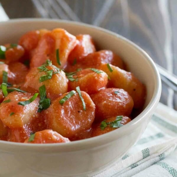 bowl with gnocchi with ricotta and tomato sauce topped with basil