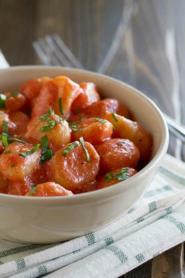 bowl with gnocchi with ricotta and tomato sauce topped with basil