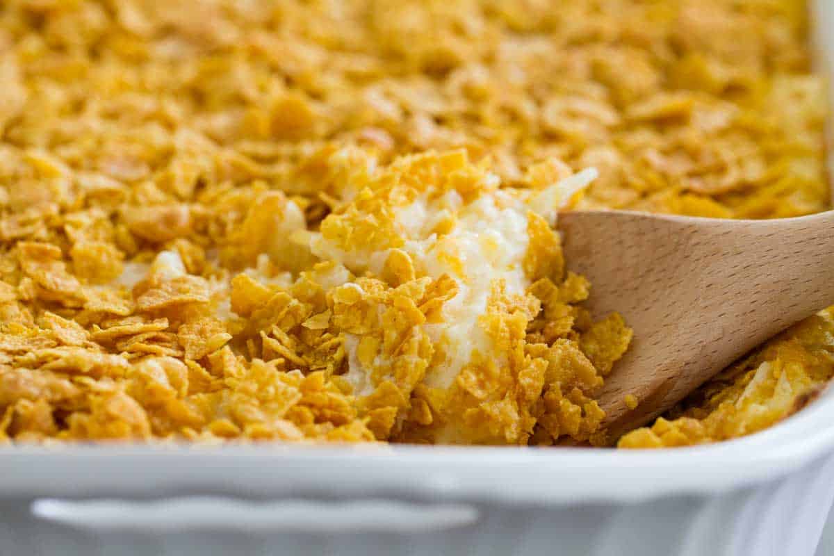 dish of funeral potatoes with wooden spoon