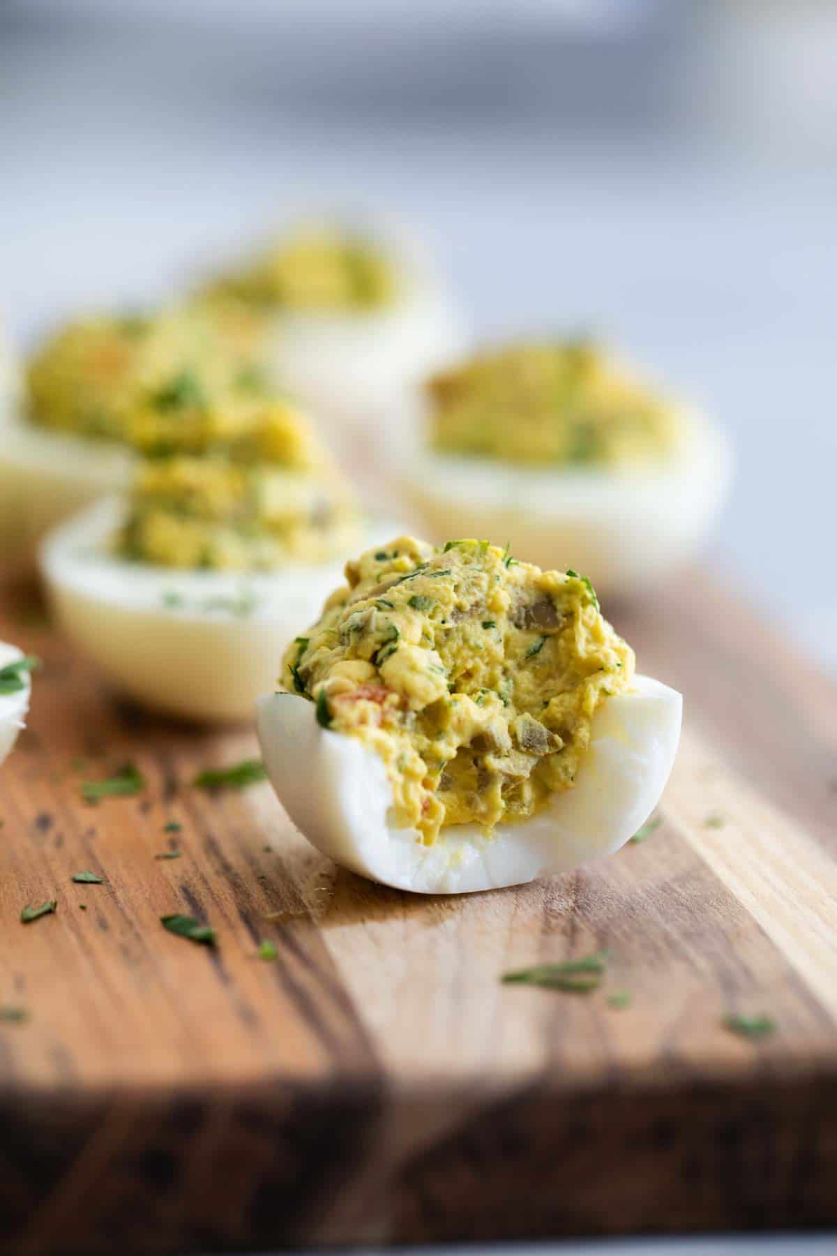 Green Olive Deviled Egg with a bite taken from it.