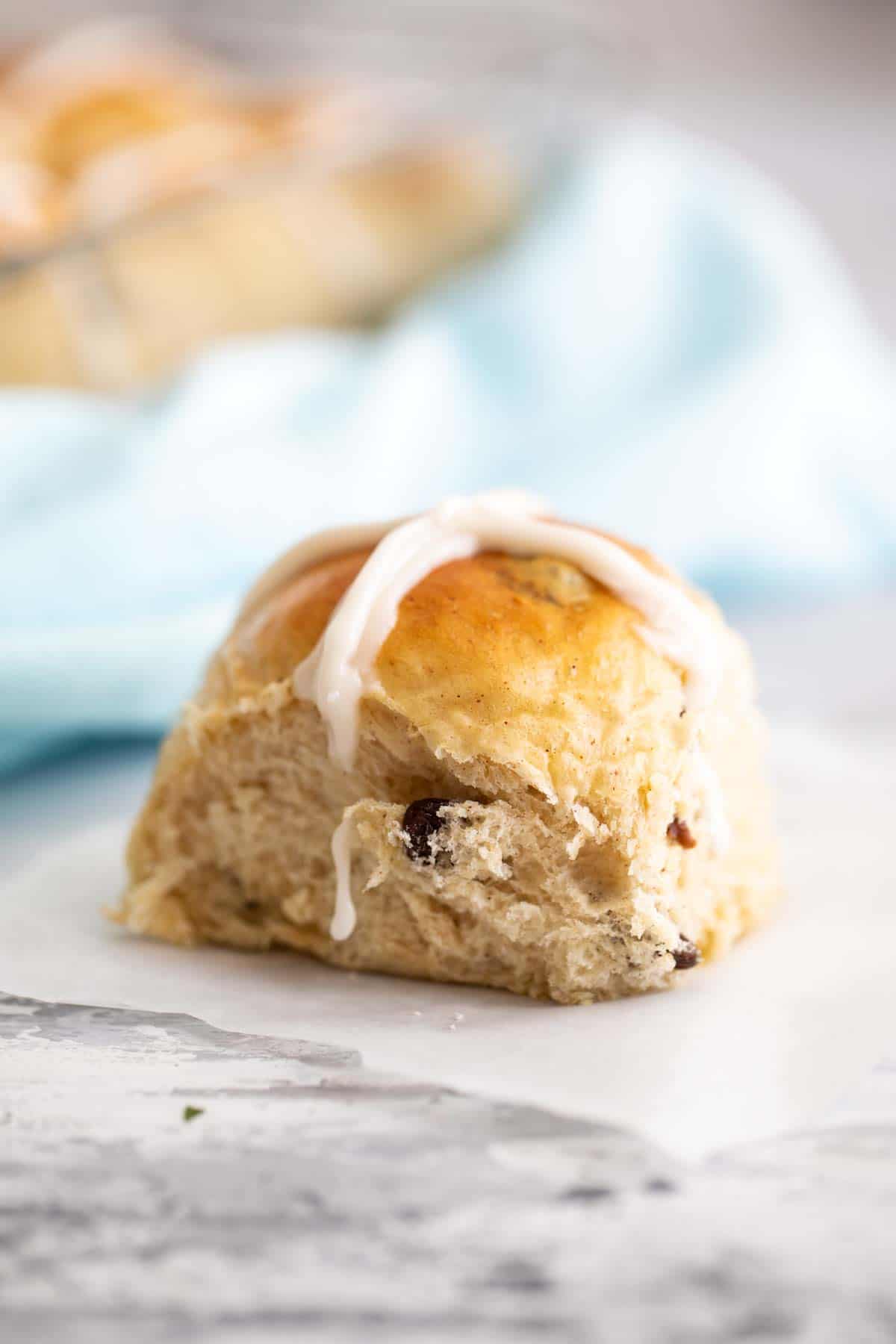 single hot cross bun on parchment paper