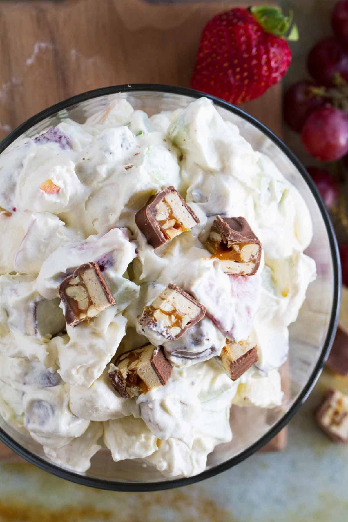 Snickers Apple Salad in a bowl topped with snickers.
