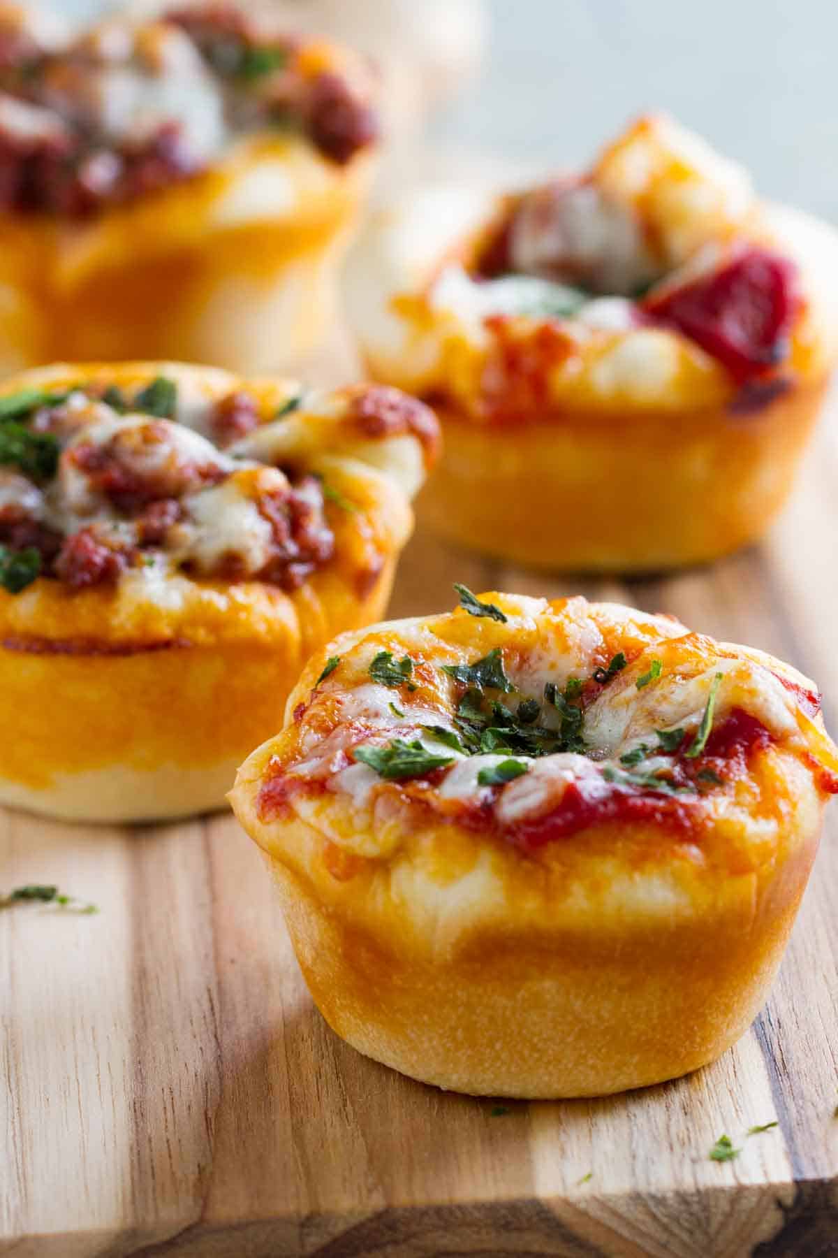 Pizza cups on a cutting board.