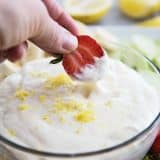 Dipping a strawberry into Lemon Cream Cheese Fruit Dip
