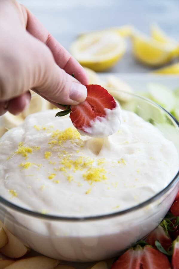Dipping a strawberry into Lemon Cream Cheese Fruit Dip