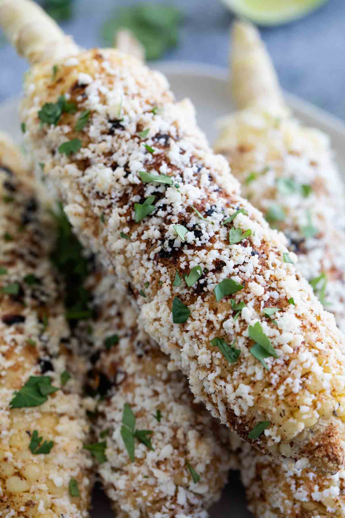 Toppings on grilled Mexican corn on the cob