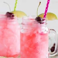 homemade slurpees in glasses with lime slices, cherries and straws
