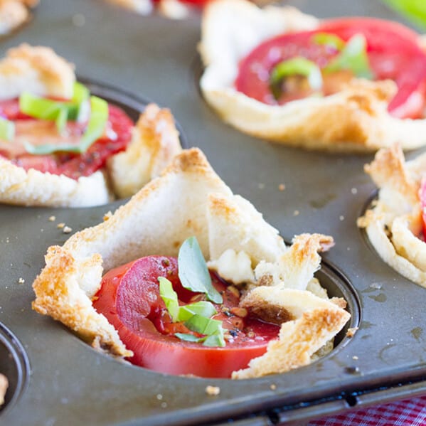 Mini tartlets filled with seasoned cream cheese, fresh mozzarella, tomato and topped with basil. These Mini Caprese Tartlets are the perfect end of summer appetizer or side dish!