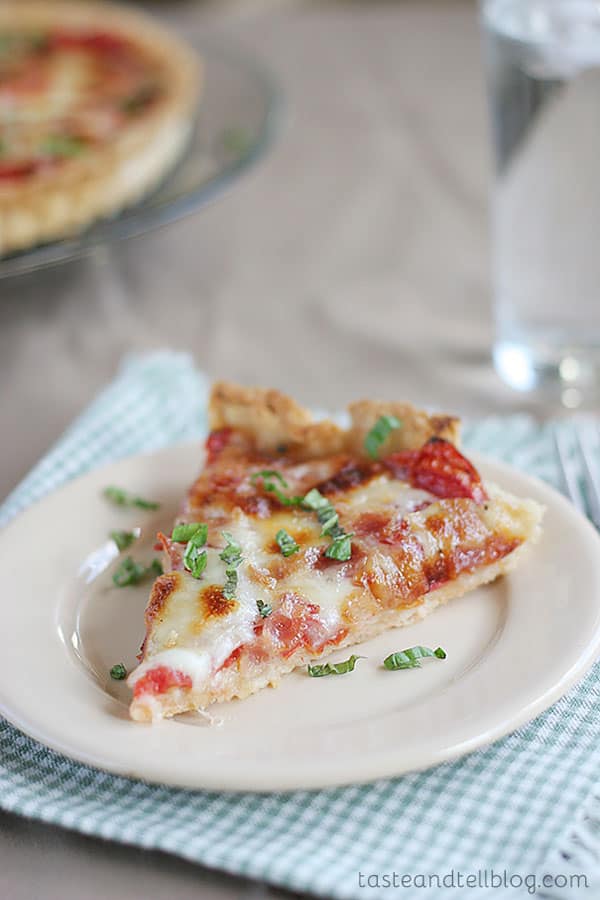 A buttery, flaky crust is filled with fresh tomatoes, bacon and lots of cheese for the perfect end of summer Tomato Tart Recipe.