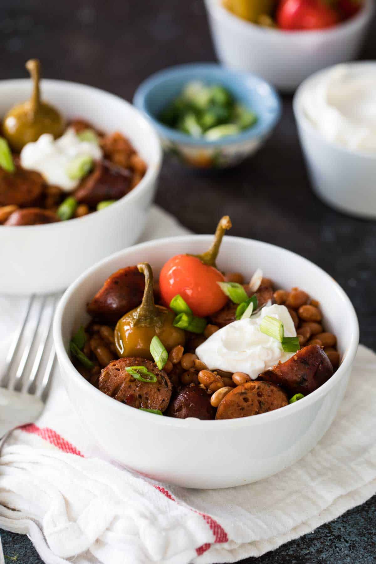 Easy Crock Pot Beans and Sausage topped with sour cream.