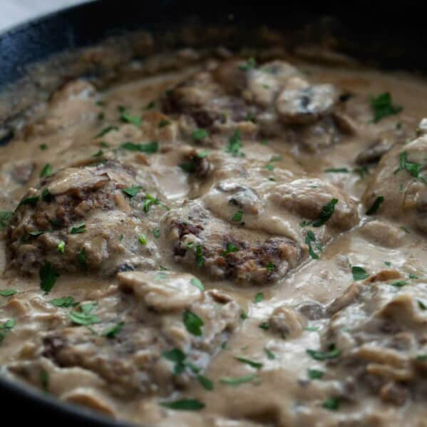 Salisbury Steak in a cast iron pan with gravy.