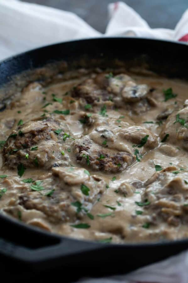 Salisbury Steak in a cast iron pan with gravy.