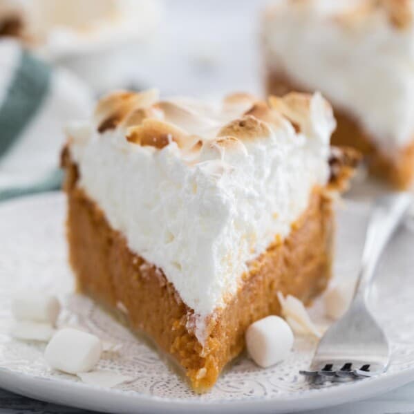 slice of sweet potato pie with tall meringue on a plate with a fork