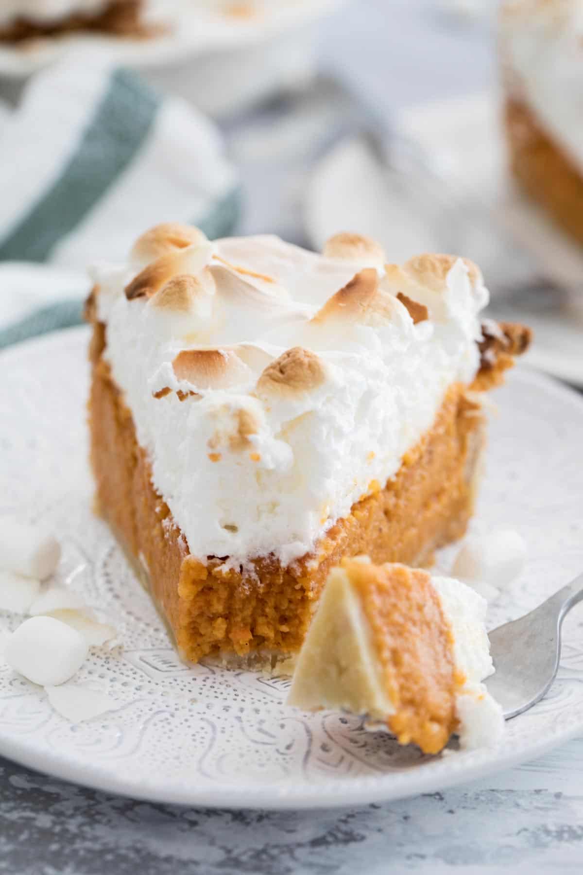 slice of sweet potato pie with a fork taking a bite