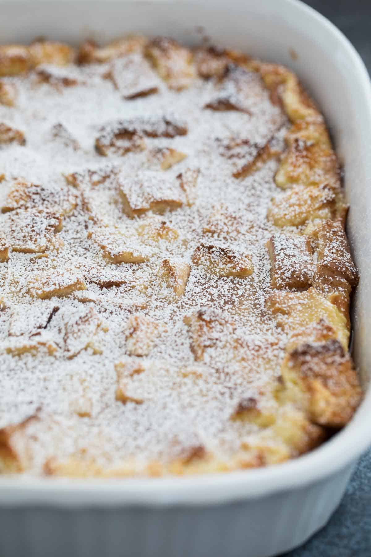 casserole dish with French Toast Casserole sprinkled with powdered sugar