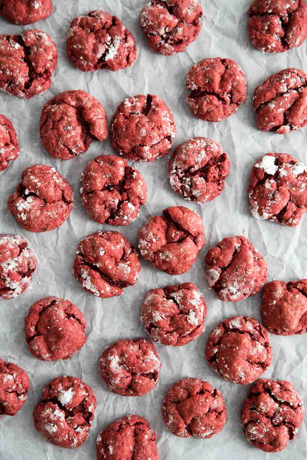 Red velvet gooey butter cookies with powdered sugar on the outside.