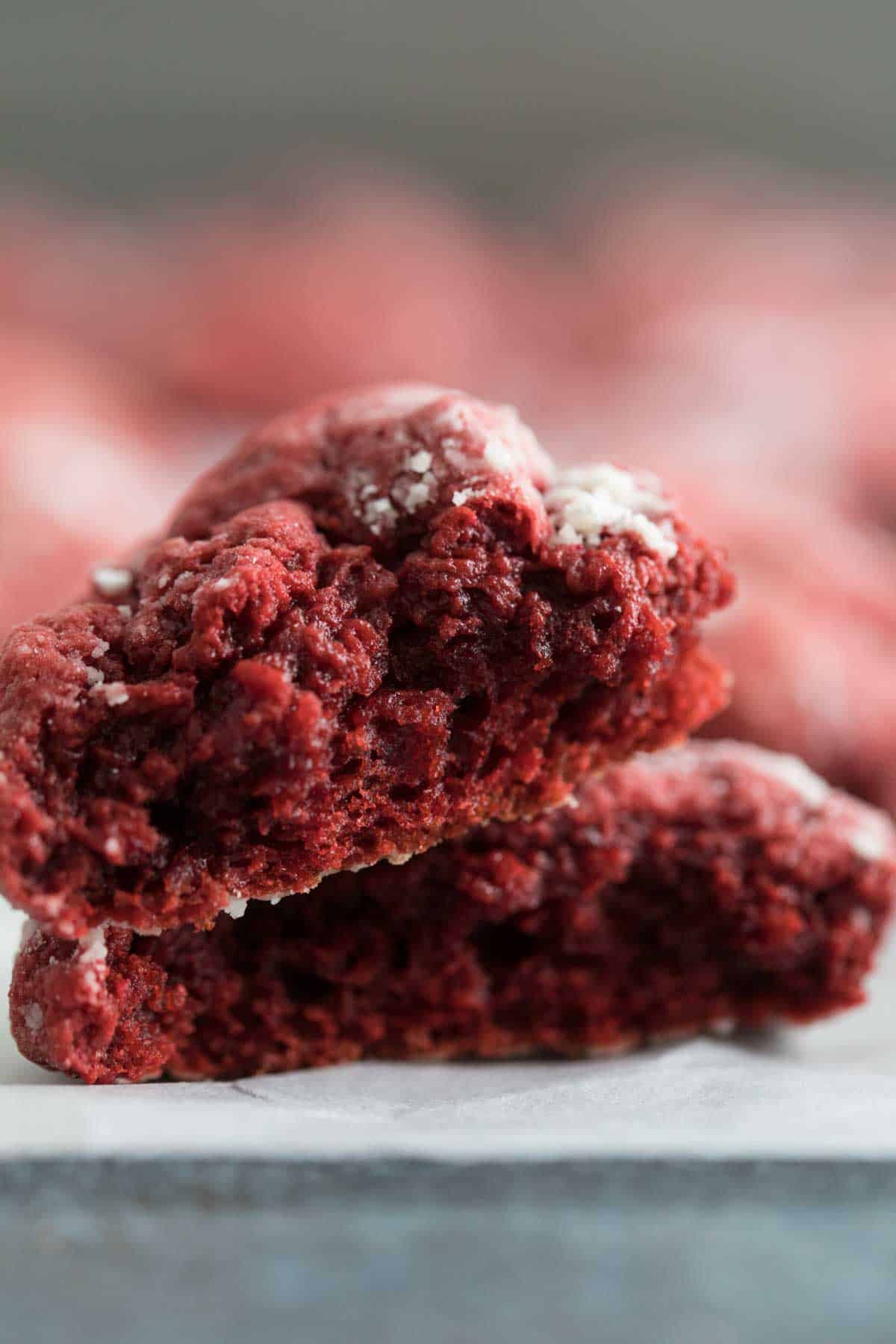 Red velvet gooey butter cookie torn in half to show the texture of the inside of the cookie.