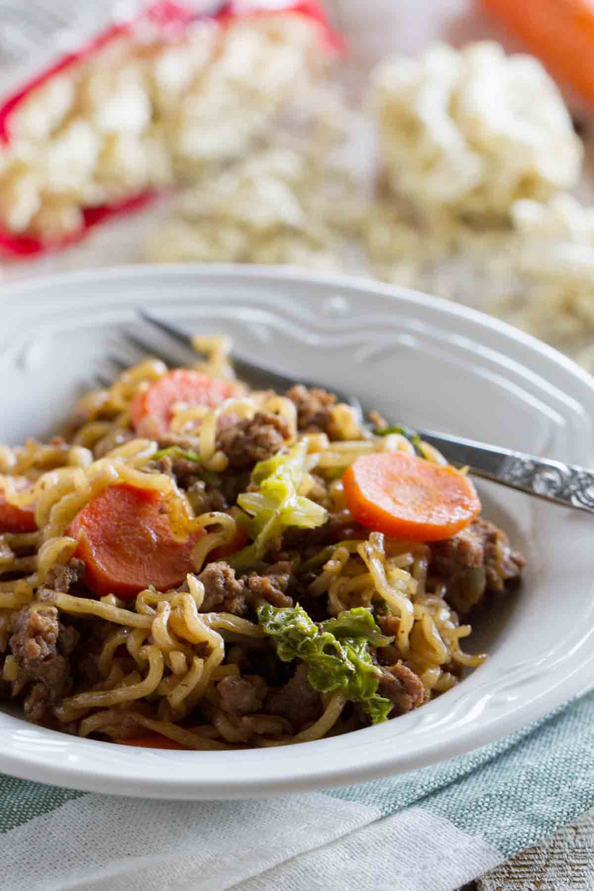 Bowl filled with Ramen Vegetable Beef Skillet with carrots and cabbage.