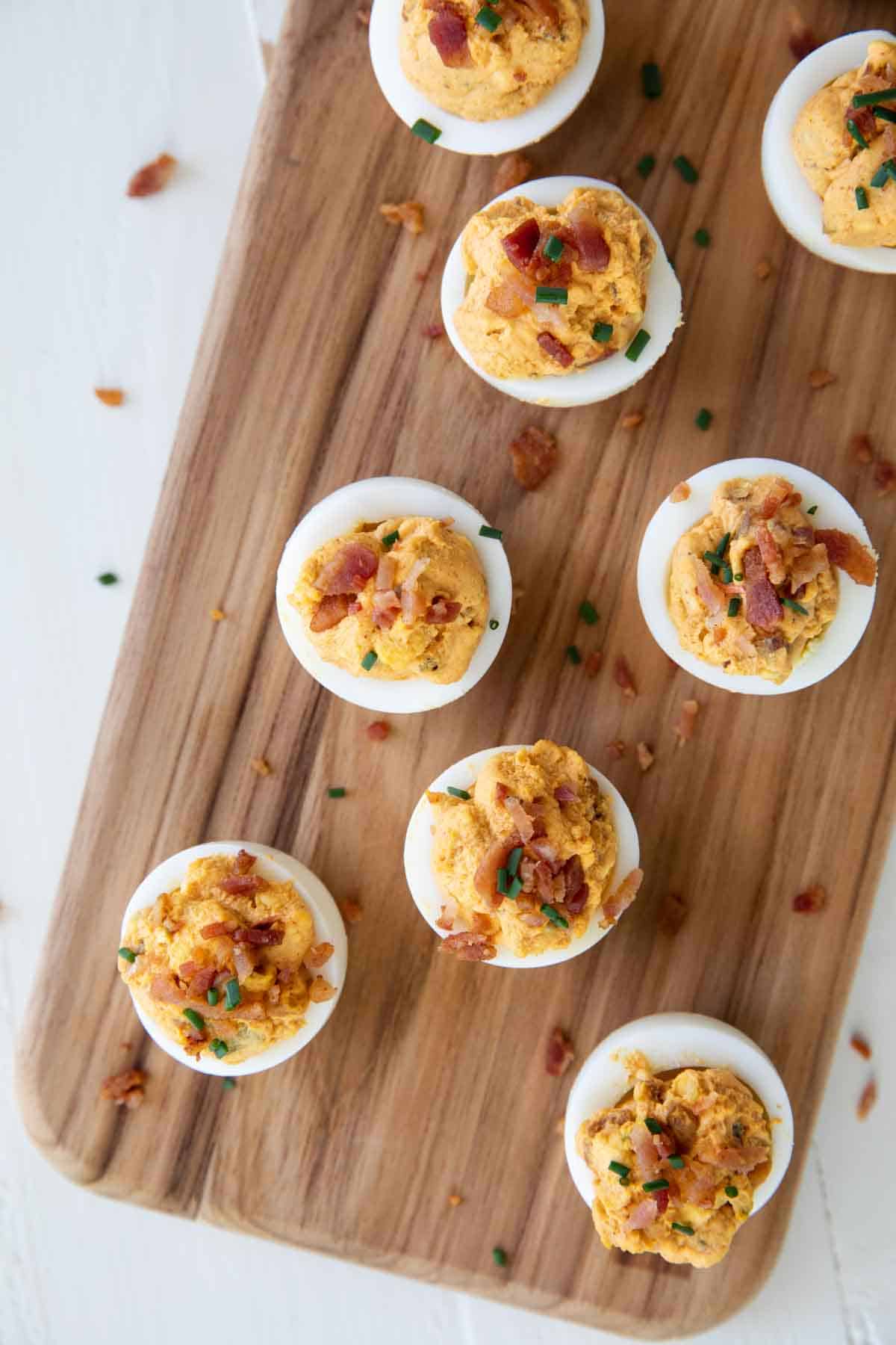 Deviled Eggs with Bacon on a cutting board.
