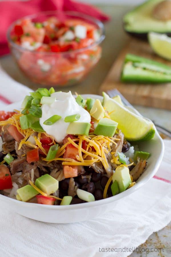 Caramelized pork carnitas are served over beans and rice, and topped with a fresh pico de gallo to make a burrito bowl that will rival the local take out joint!