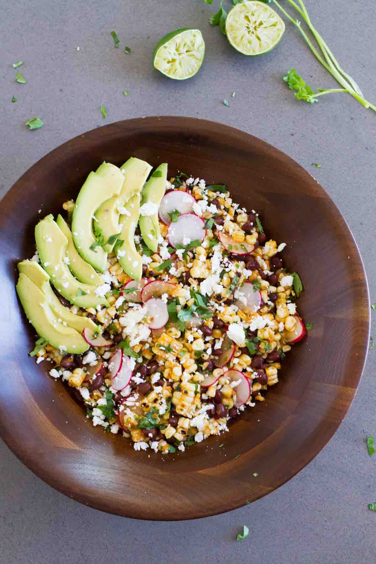 wooden bowl filled with grilled corn and black bean salad