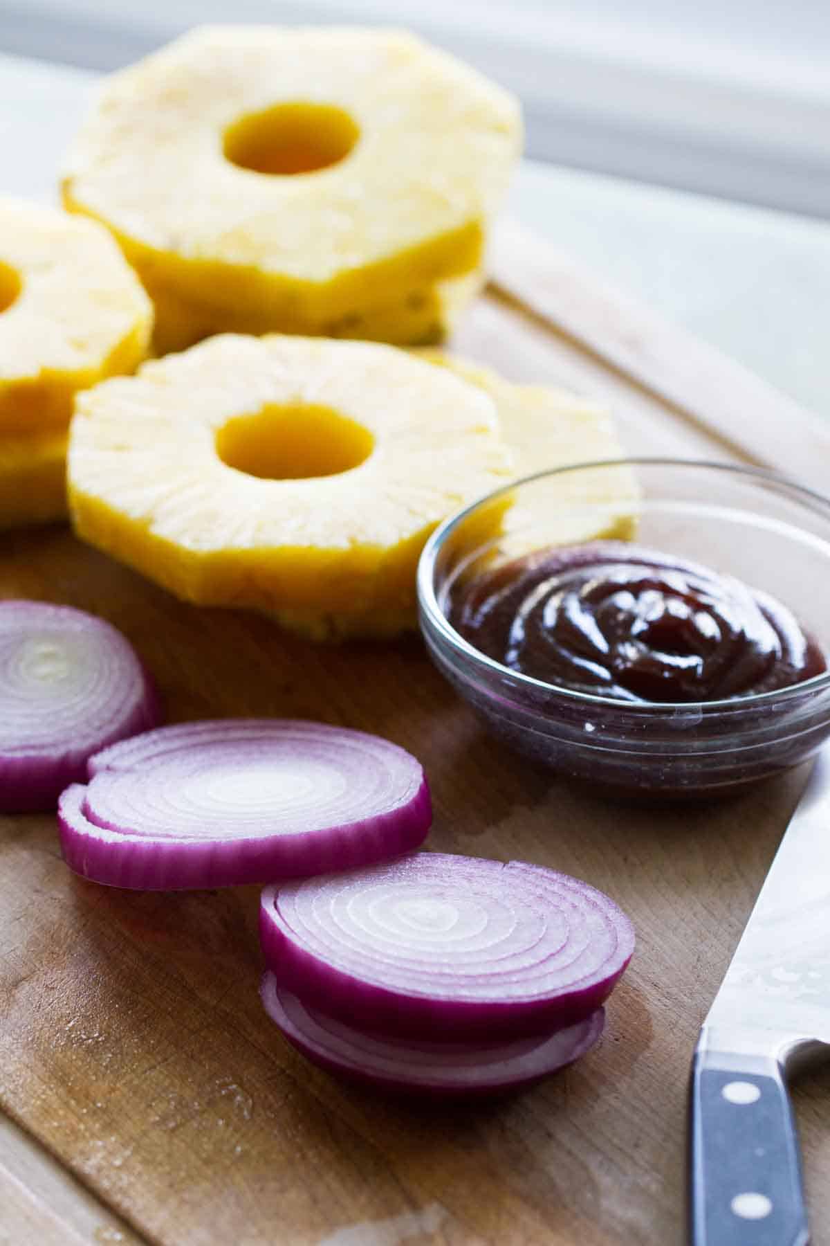 Take a taste of the tropics with these Hawaiian Hot Dogs - grilled hot dogs topped with grilled fresh pineapple and onions for a Hawaiian flair. pineapple, onion, and barbecue sauce for Hawaiian Hot Dogs