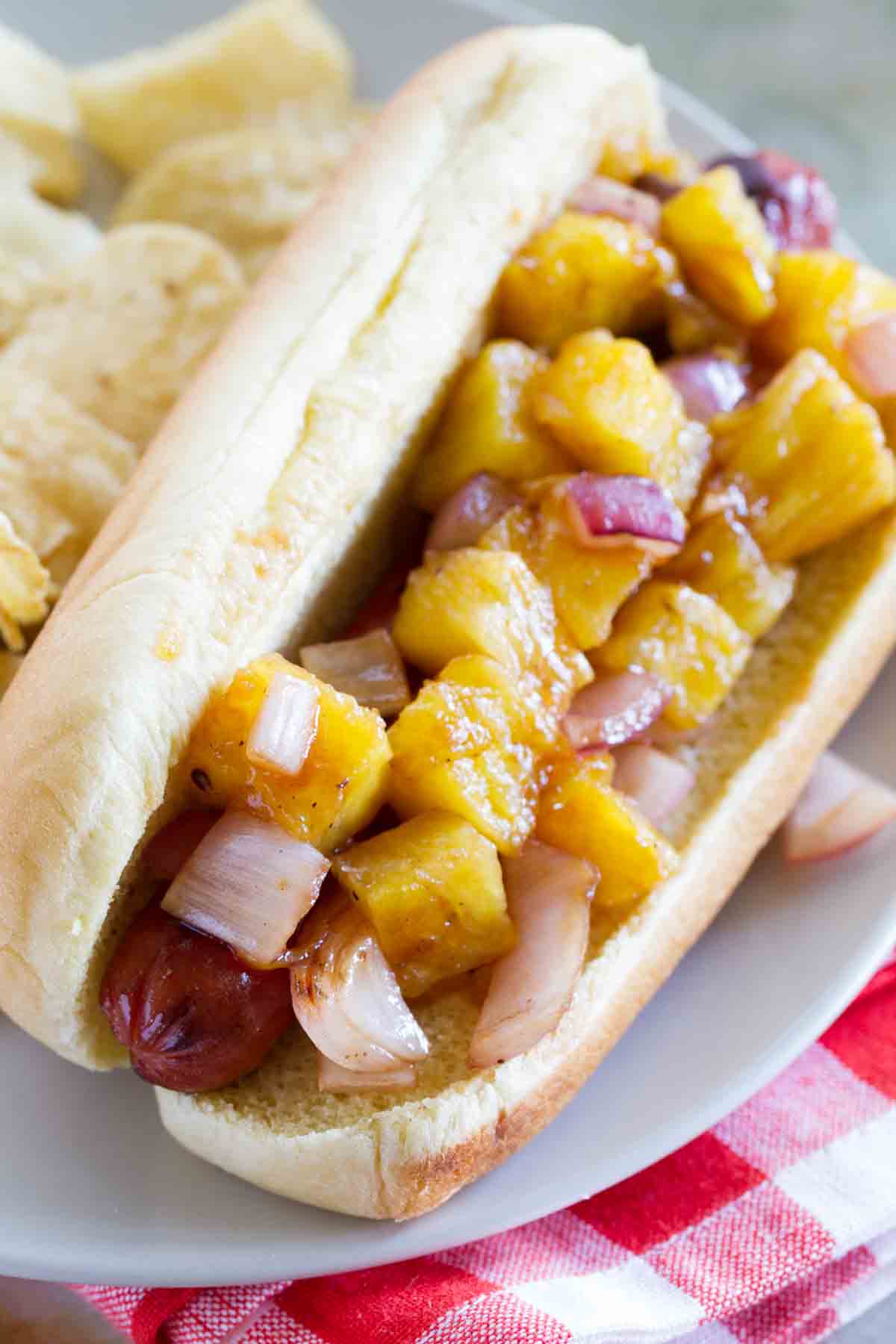 Hot dog topped with grilled pineapple, onion, and barbecue sauce