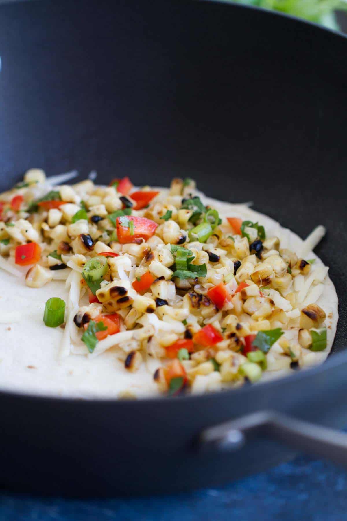 Making a grilled corn quesadilla in a skillet