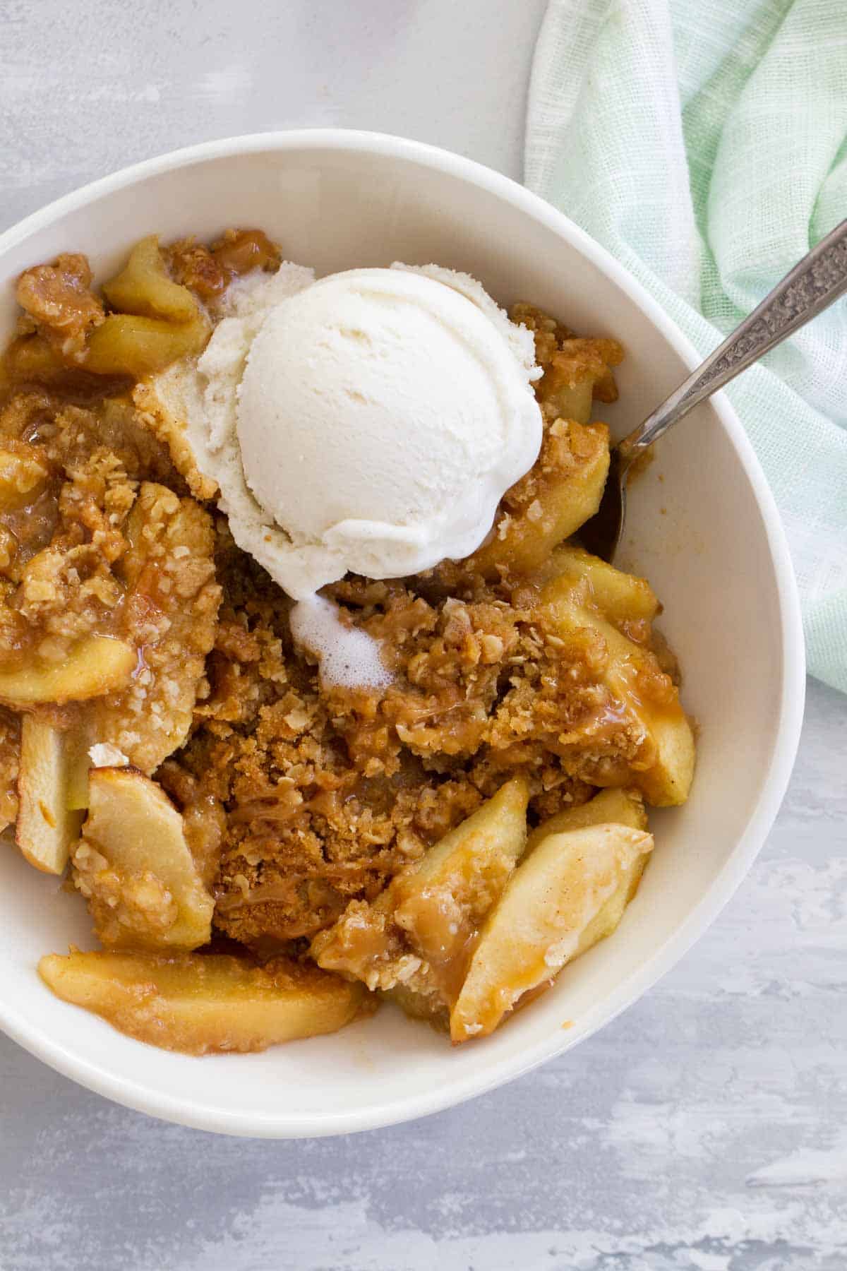 Caramel Apple Crisp topped with vanilla ice cream and caramel.