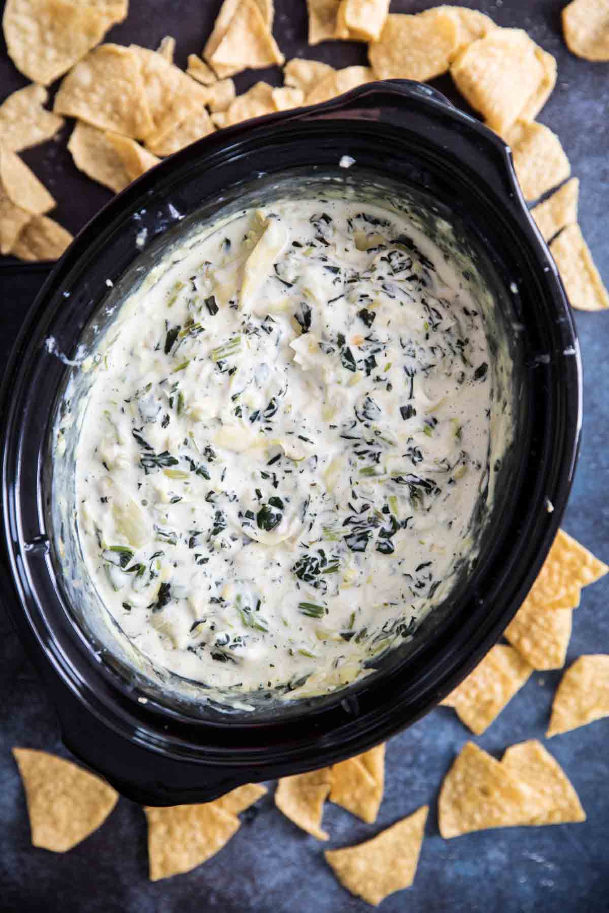 Spinach Artichoke Dip in the Slow Cooker surrounded by tortilla chips