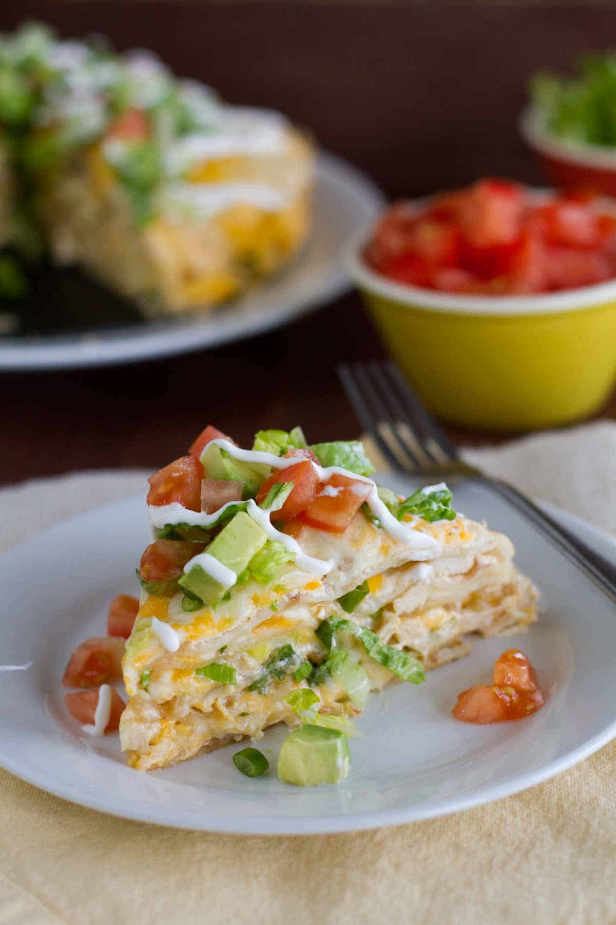 slice of chicken tortilla stack topped with tomatoes and avocado