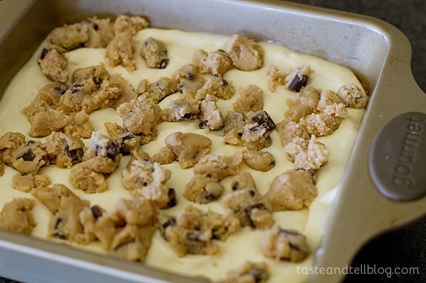 Placing cookie dough pieces on for caramel cookie cheesecake bars.