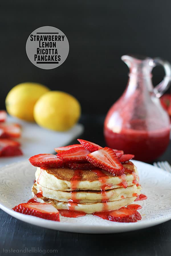 Light lemon and nutmeg scented pancakes are topped with fresh strawberry syrup and fresh strawberries.