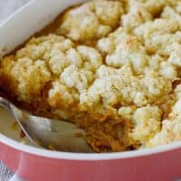 Dish filled with Pumpkin Cobbler - a fall dessert with pumpkin custard topped with a sweet biscuit topping.