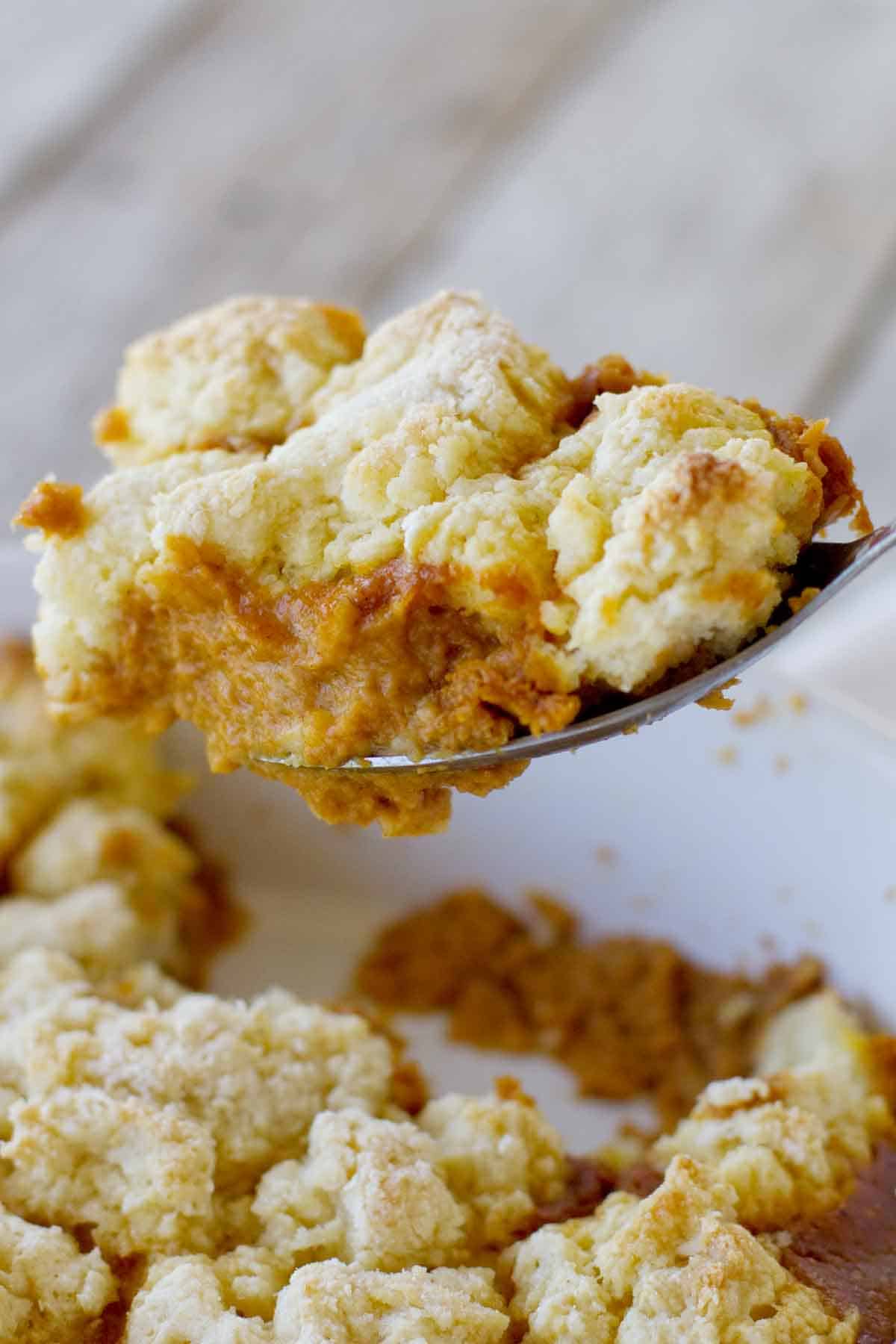 Spoon with scooping out a portion of Pumpkin Cobbler.