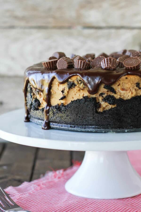 full Reese's Peanut Butter Cheesecake on a cake stand.