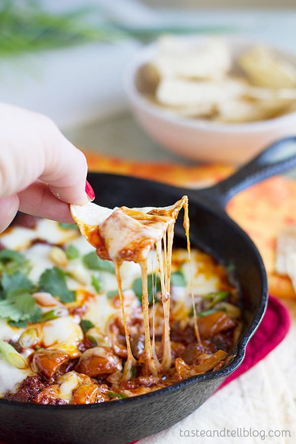 Chip dipping into chorizo mushroom queso dip.